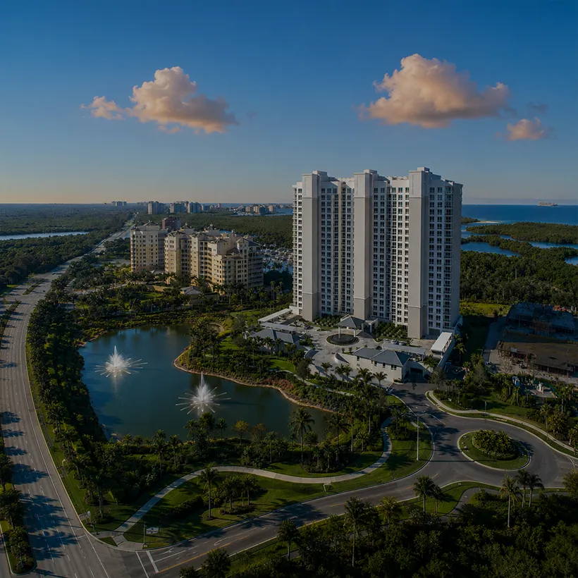 High-Rise Condos in Naples, Florida: aerial view of the Kalea Bay high-rise towers above the entry lake and mangroves in North Naples, Florida