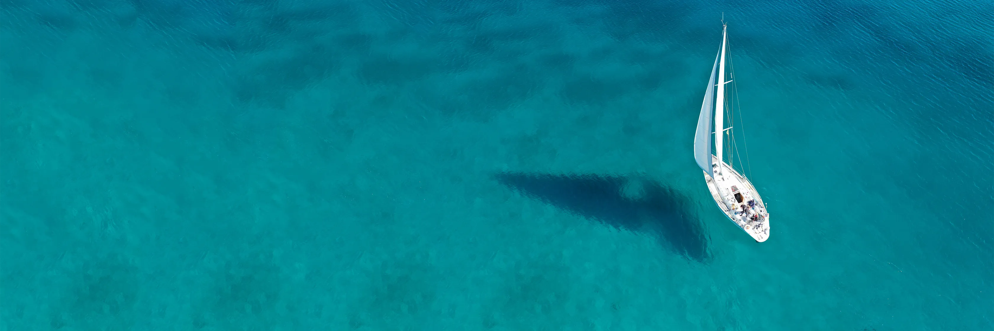 Sailboat on clear Gulf of Mexico water seen from above, near Vanderbilt Beach in Southwest Florida