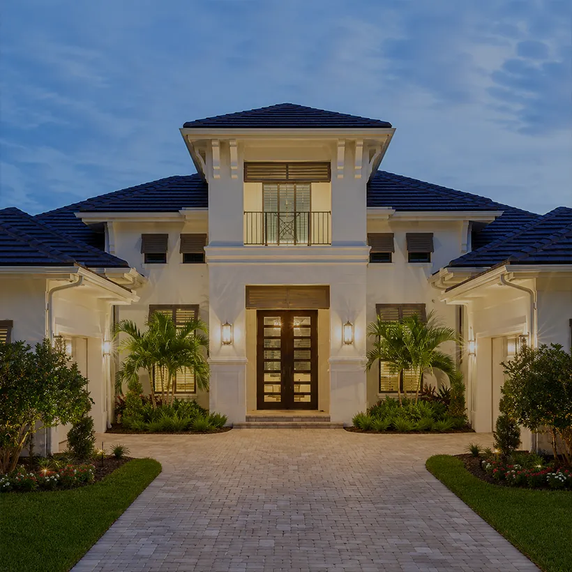 Foreclosure Homes in Naples, Florida: coastal-contemporary home with lit entry and paver walk at dusk in Twin Eagles, Naples, Florida