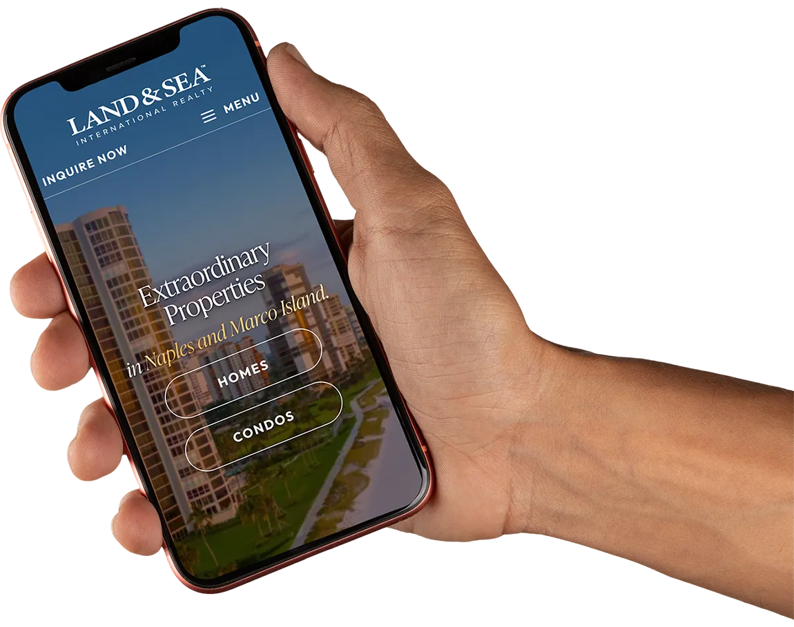 Hand holding a smartphone showing the Land & Sea International Realty website, where buyers search every Naples and Marco Island listing