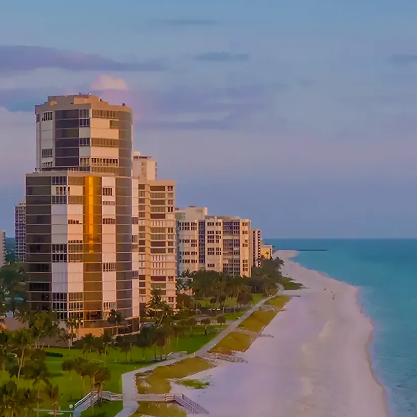 High-rise condominium towers along the beach and the Gulf at dusk in Naples, Florida