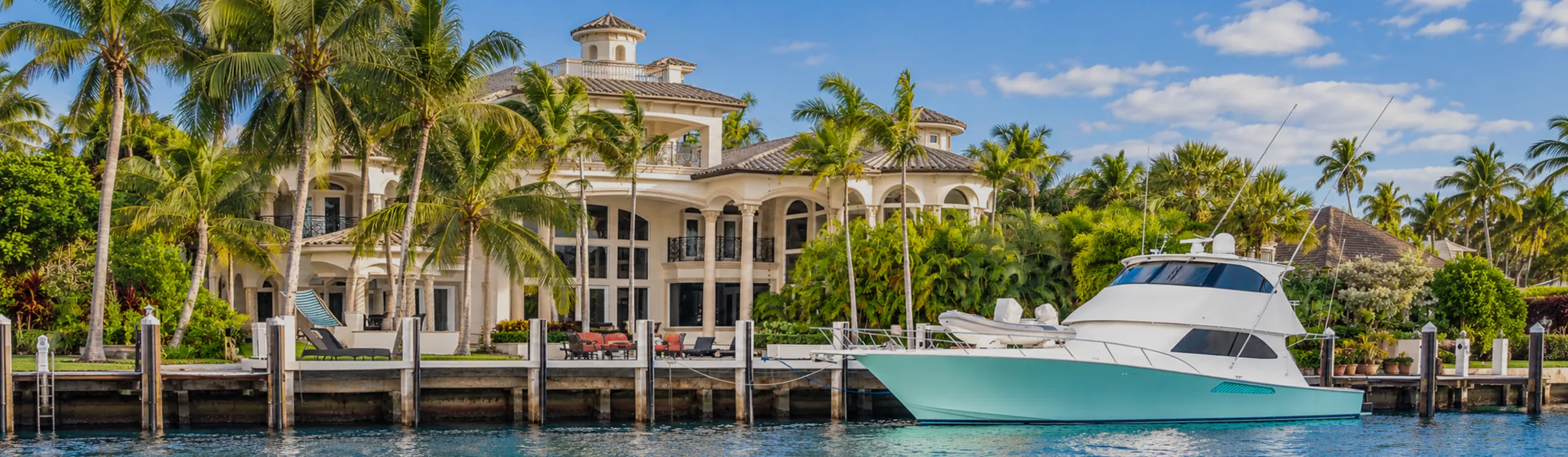 Sport-fishing boat at the dock of a deep-water estate in Naples, Florida, the kind of property Land & Sea represents