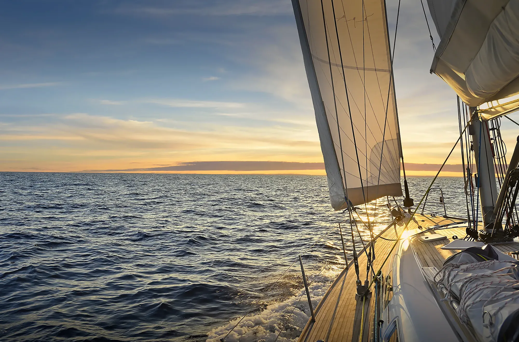 Sailboat under full sail on the open Gulf of Mexico at sunset off Naples, Florida